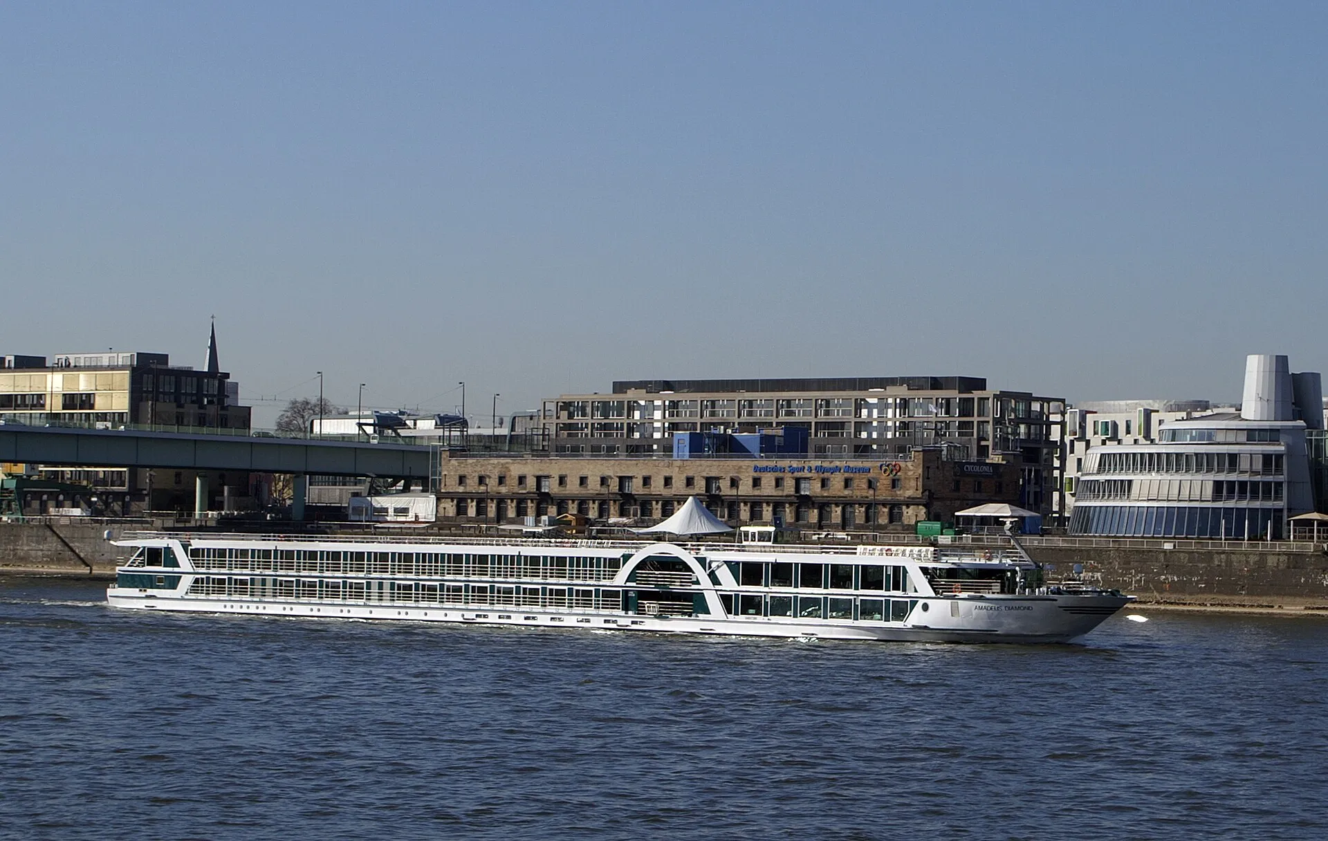 Flusskreuzfahrtschiff Amadeus Diamond auf Fahrt vor dem Deutschen Sport- und Olympiamuseum in Köln.