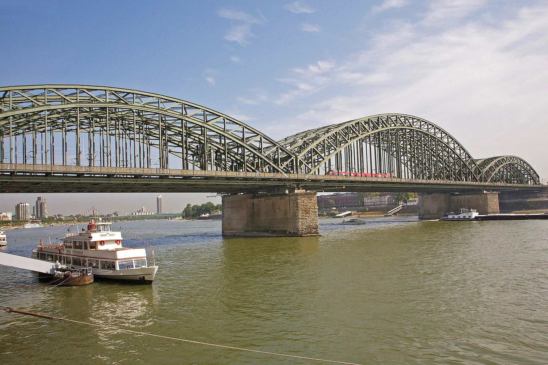 The Hohenzollern Bridge in Cologne spans the Rhine with a length of 409 meters. The bow bridge, built between 1907 and 1911, consists of two tracks and a walkin