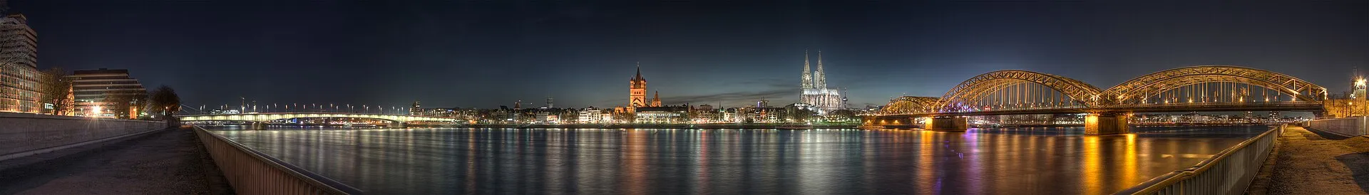 Panoramic view of the old town of Cologne ( North Rhine-Westphalia , Germany ) taken from the other side of the river Rhine at dusk (09:58pm). You can see (from